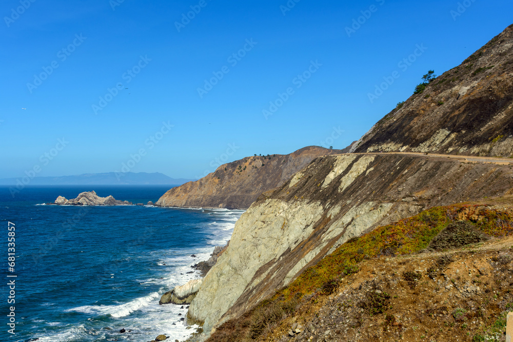 Scenic landscape of California coast showcasing the blue ocean, rugged cliffs, and a clear sky near Devils Slide trail