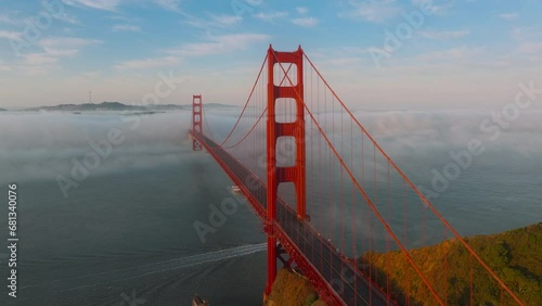 Scenery shot of Golden Gate Bridge and route 101 show off in San Francisco Bay in morning fog, California, USA. Drone view of red bridge and the city of San Francisco surrounded thick mist, 4k footage