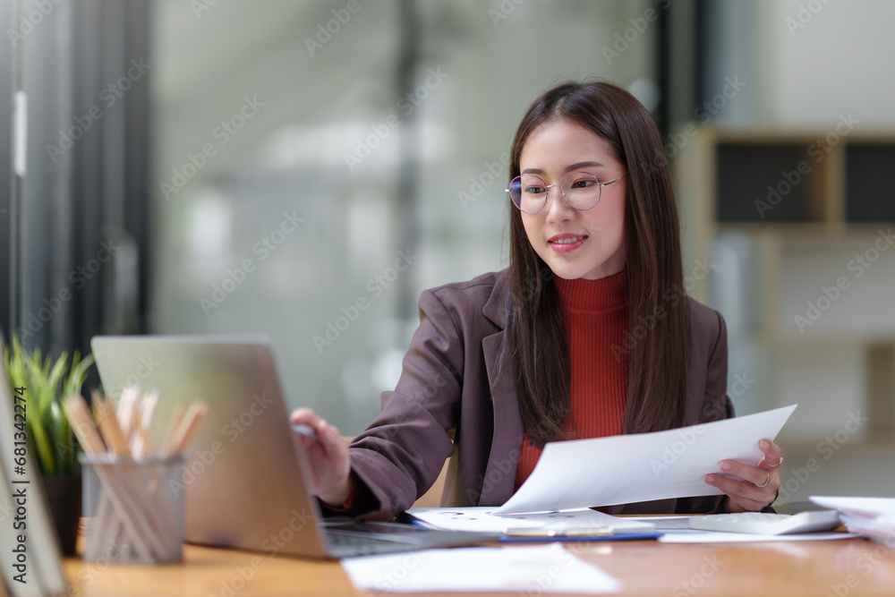 Asian businesswoman smiling using laptop computer at office. Confident Asia businesswoman sitting happily in the office. Asian businesswoman smiling using laptop computer at office. Confident Asia businesswoman sitting happily in the office.