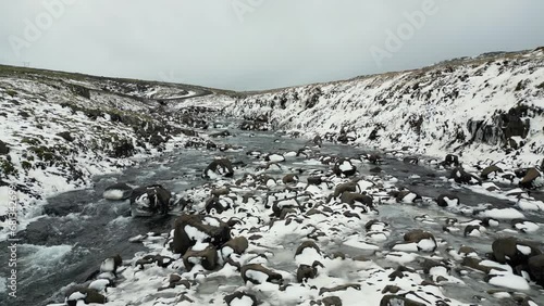 Snowy Rocks on Flowing River in Iceland Winter, Beautiful Landscape, Aerial photo