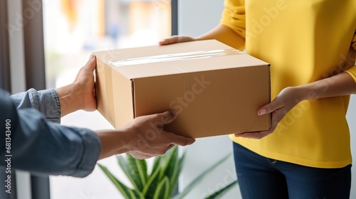 Delivery man brought a cardboard box and gives it to the client, home delivery photo