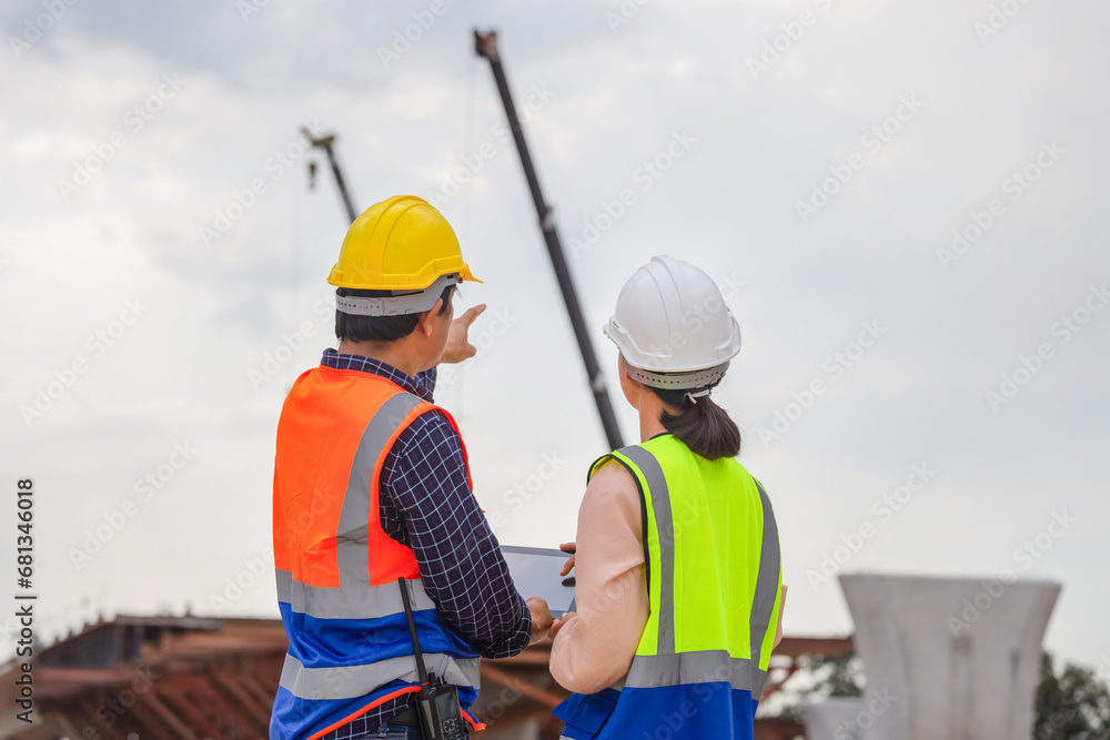 Female engineer and foreman worker checking project at building site, Engineer and builders in hardhats discussing on construction site, Teamwork concepts Female engineer and foreman worker checking project at building site, Engineer and builders in hardhats discussing on construction site, Teamwork concepts