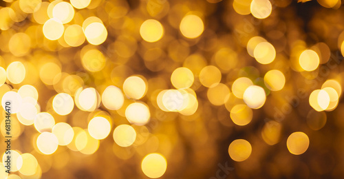 Beautiful Festive Golden abstract Background with bokeh lights. Amazing holiday Golden color texture for design. Wide Screen Wallpaper with Decorative pattern of lights spots