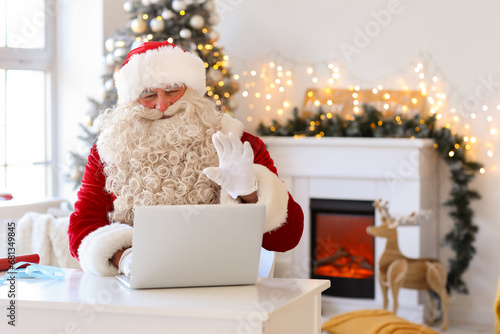 Santa Claus using laptop at...