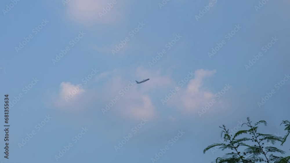Climbing up and gaining altitude just after takeoff also revealing branches with leaves, blue sky, some fluffy clouds, Nok Air, Don Mueang International Airport, Bangkok, Thailand Climbing up and gaining altitude just after takeoff also revealing branches with leaves, blue sky, some fluffy clouds, Nok Air, Don Mueang International Airport, Bangkok, Thailand