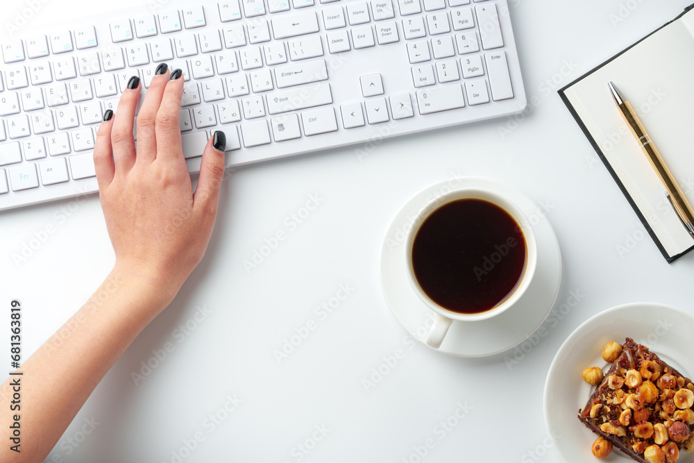 Female hands typing on kieyboard with coffee and cake on table Female hands typing on kieyboard with coffee and cake on table