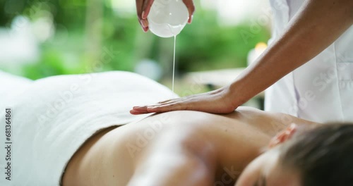 Woman, massage therapist and oil for back, spa and skin for physical therapy, treatment and neck. Body care, masseuse and wellness for selfcare, peaceful and hands in luxury resort and tranquility photo