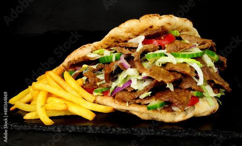 Doner kebab meat and French fries in a naan bread with salad