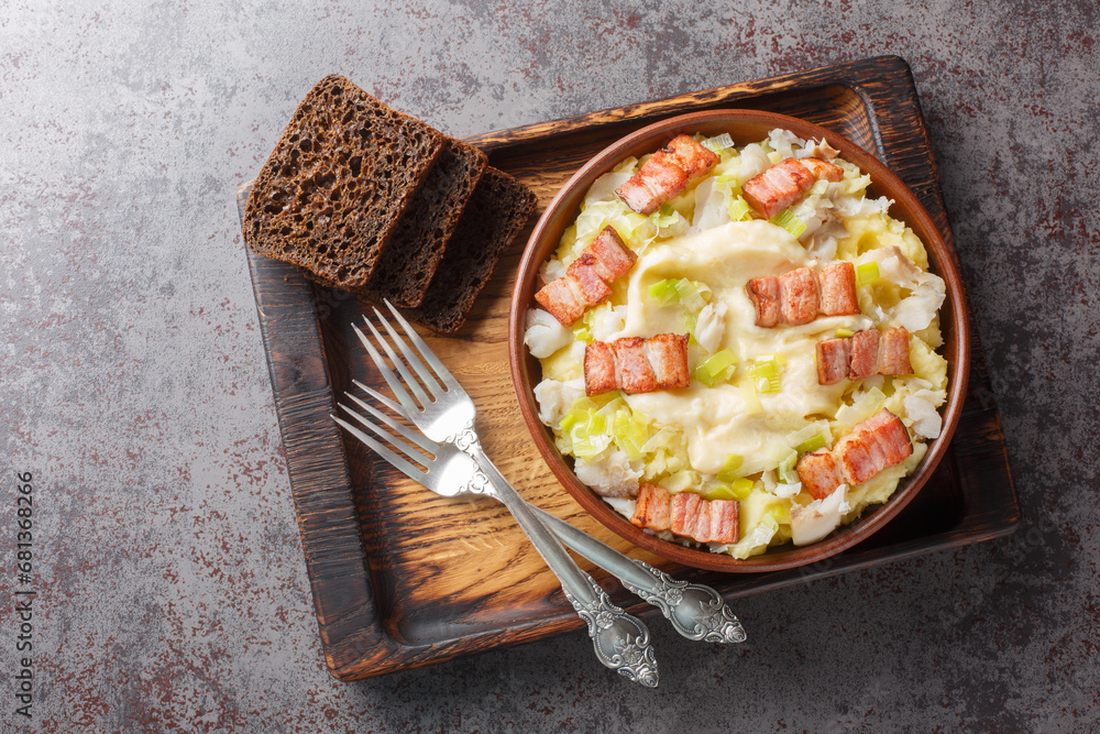 Norwegian Plukkfisk consists of potatoes, pieces of fish, and onions cooked in a bechamel sauce close up on a plate on the table. Horizontal top view from above