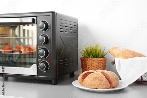 Mini electric oven with baked cakes inside