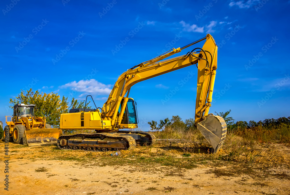 The yellow backhoe was parked after finishing work The yellow backhoe was parked after finishing work