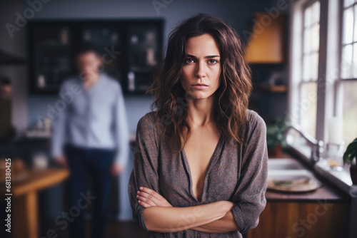 Brunette woman feeling sad and disappointed, her husband is behind photo