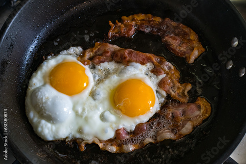 Idea for healthy breakfast two fried eggs and bacon in a pan.