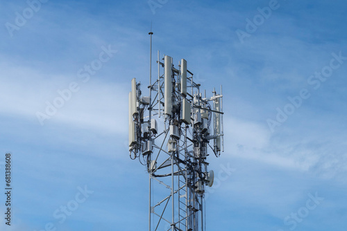 Telecommunication tower of 4G and 5G cellular. Macro Base Station. 5G radio network telecommunication equipment with radio modules and smart antennas mounted on a metal against cloulds sky background.