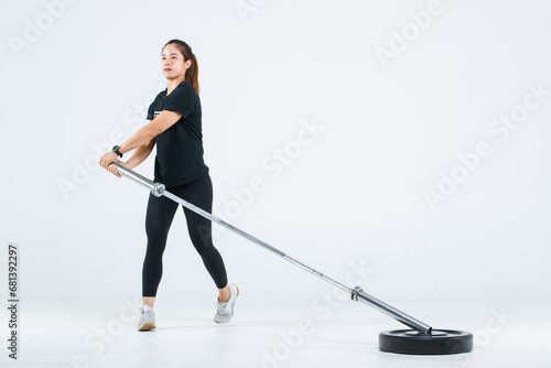 Isolated cutout full body studio shot of strong Asian female fitness athlete sportswoman trainer model in casual sport workout outfit posing training exercising lifting barbell on white background photo