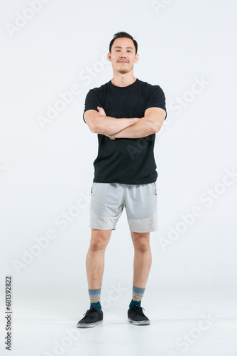 Portrait isolated cutout full body studio shot of strong Asian male fitness athlete sportsman professional trainer model in casual sport workout outfit standing smiling posing on white background