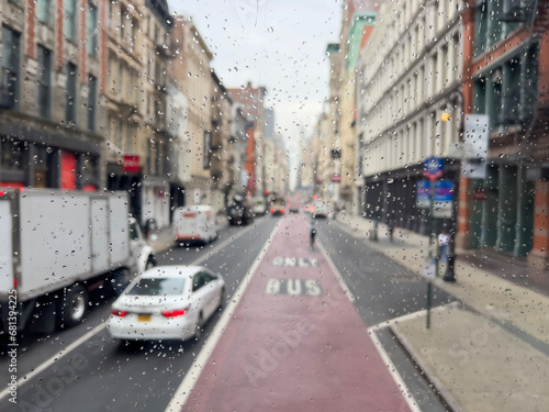 rain drops on car window over traffic and street in New York, USA