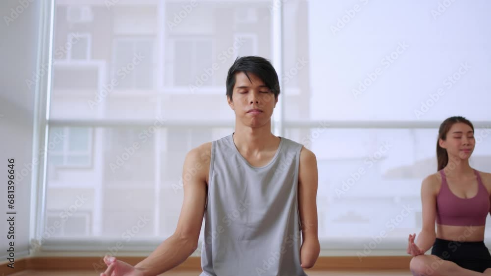 Asian young amputee male without arm doing yoga in the fitness gym. Asian young amputee male without arm doing yoga in the fitness gym.