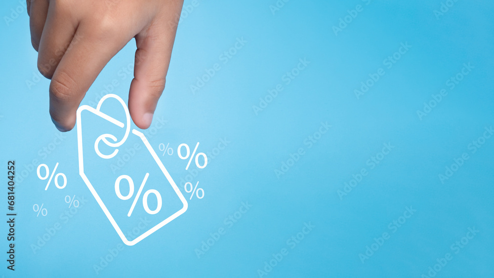 Human hand holds discount percentage sign icon on light blue background represents online shopping concept, special price products and promotions. - obrazy, fototapety, plakaty 