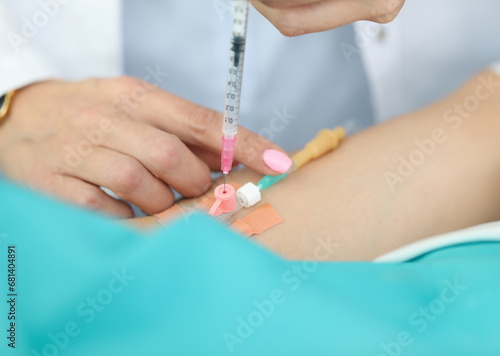 Focus on tender hands of experienced woman. Professional nurse introducing syringe with medicine in dropper in hospital. Healthcare and medicine concept