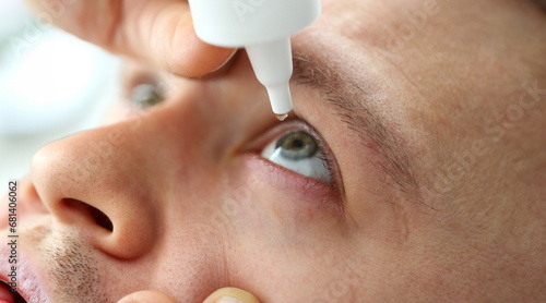 Man putting liquid drops in his eye solving vision problem closeup