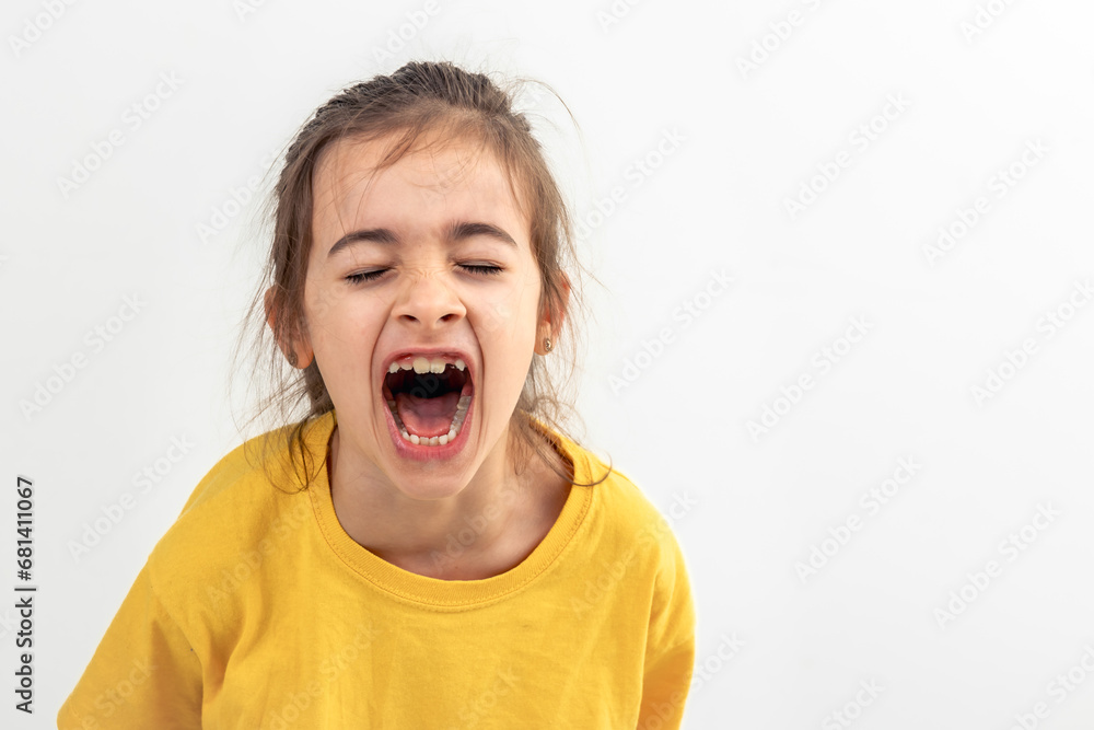 A little Caucasian girl screams loudly, isolated on white background. A little Caucasian girl screams loudly, isolated on white background.