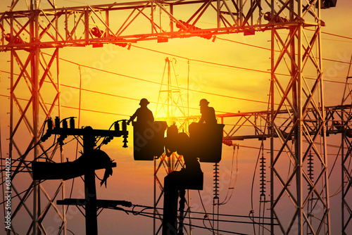 silhouette group of electrician engineer on cradle of aerial platform or crane worked over rate in electric constrution site on sun setabstract nature background, tecchnology concept