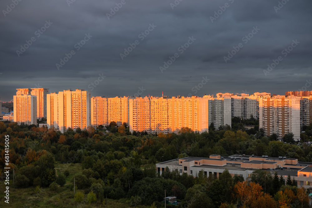 Tall multi-storey buildings in the rays of the setting sun. A beautiful residential area of the city at sunset against a cloudy sky. Multi-storey residential buildings in an urban area at sunset. Tall multi-storey buildings in the rays of the setting sun. A beautiful residential area of the city at sunset against a cloudy sky. Multi-storey residential buildings in an urban area at sunset.