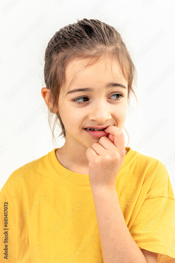 Scared and anxious girl, biting her fingernails on a white background isolated. Scared and anxious girl, biting her fingernails on a white background isolated.