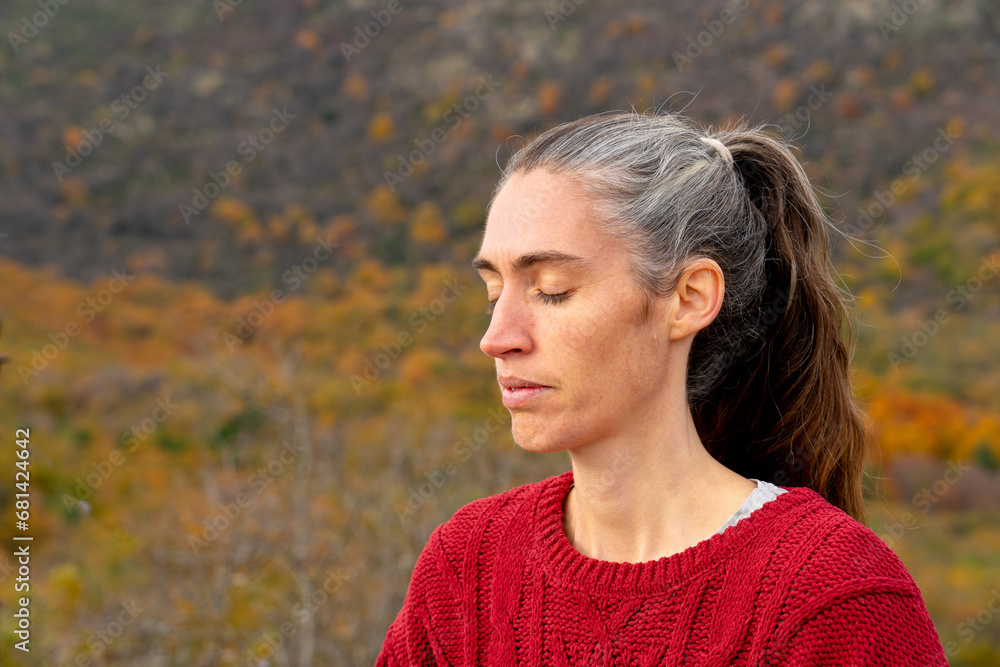 Middle aged woman meditating in nature Middle aged woman meditating in nature
