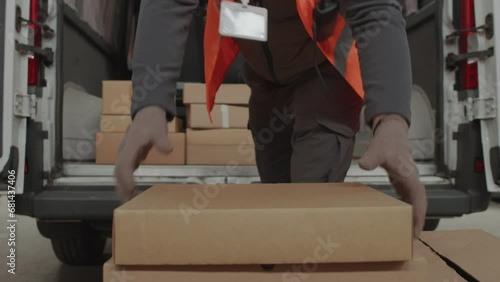 Cropped shot of storeman putting boxes for shipment into cargo van while working at warehouse