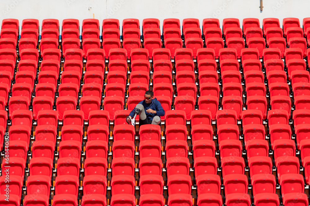 Fototapeta premium Disabled athletes in a blue shirt sitting on the red seats at the stadium, Prepare for running training.