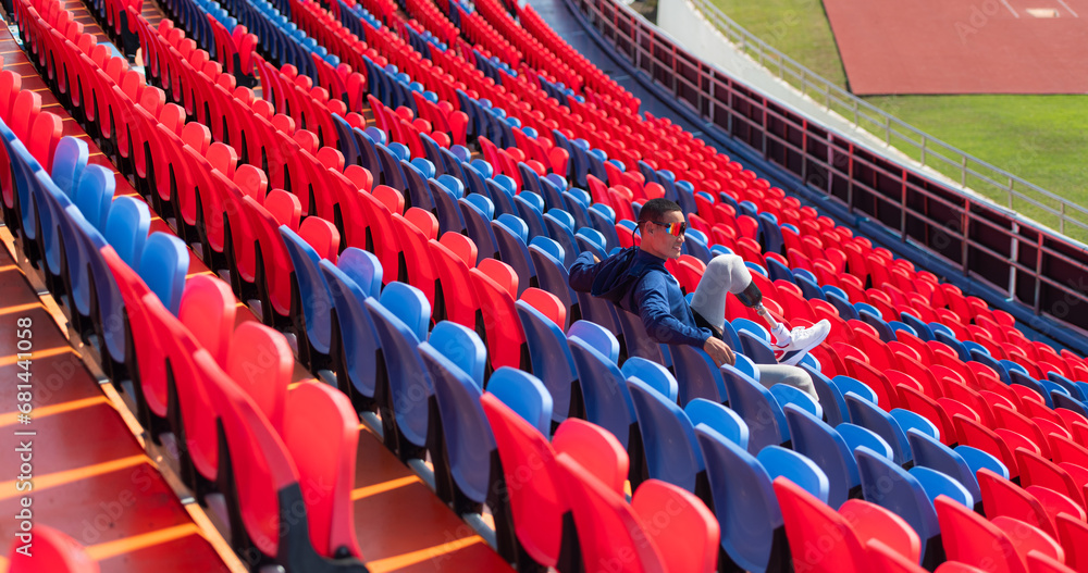 Naklejka premium Disabled athletes prepare their bodies on amphitheater in a sports arena on a sunny day before entering a short-distance running competition