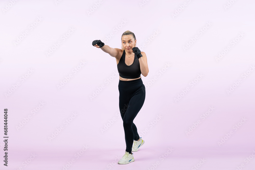 Full body length shot athletic and sporty senior woman doing boxing and punching fist posture on isolated background. Healthy active physique and body care lifestyle after retirement. Clout