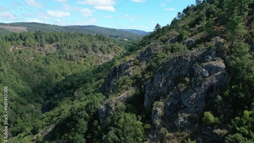 Drone footage of rocky mountains covered with green dense woods on a sunny day in Silleda, Spain photo