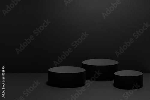 Abstract black scene with three cylinder podiums template with light beams for presentation cosmetic products, goods, advertising, design, poster. Black stage template rich contemporary concert style.