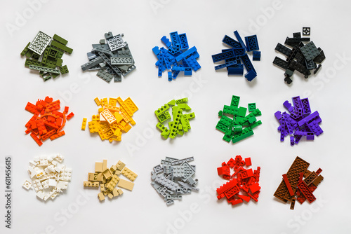 Pile of many various colored stackable plastic toy bricks isolated on white background. Top view