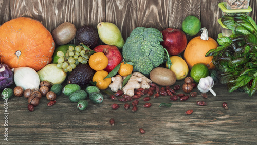 Set of fresh fruits and nuts on wooden background. Pumpkin, tangerine, kiwi, grape, apple, sweetie, lemon, feijoa, nuts, selective focus. photo