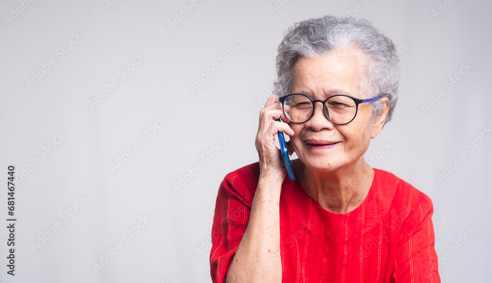 Senior woman using a smartphone while sitting at the desk Senior woman using a smartphone while sitting at the desk
