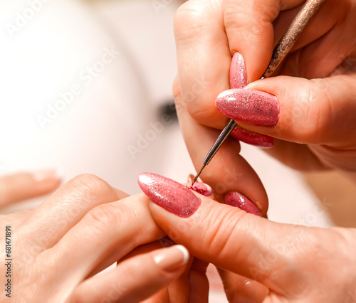 Master of manicure paints nails. Selective focus photo