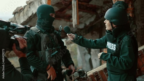Bomb explodes during the filming of an journalistic interview with a soldier in a war zone, war correspondents and soldiers run for shelter photo