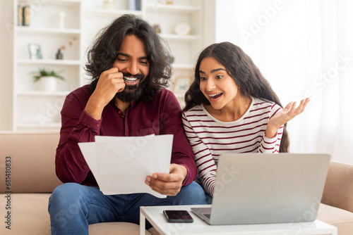 Smiling Millennial Indian Couple Discussing Total Amount Of Their Spends photo