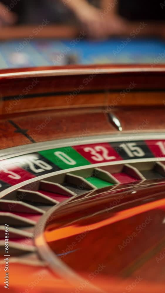 Vertical Screen: Spinning Roulette Wheel with a Ball Stopping at Number Twenty Seven Red. Casino, Gambling, Betting, Winning and Nightlife Concept. Cinematic Zoom In Close Up Footage Vertical Screen: Spinning Roulette Wheel with a Ball Stopping at Number Twenty Seven Red. Casino, Gambling, Betting, Winning and Nightlife Concept. Cinematic Zoom In Close Up Footage