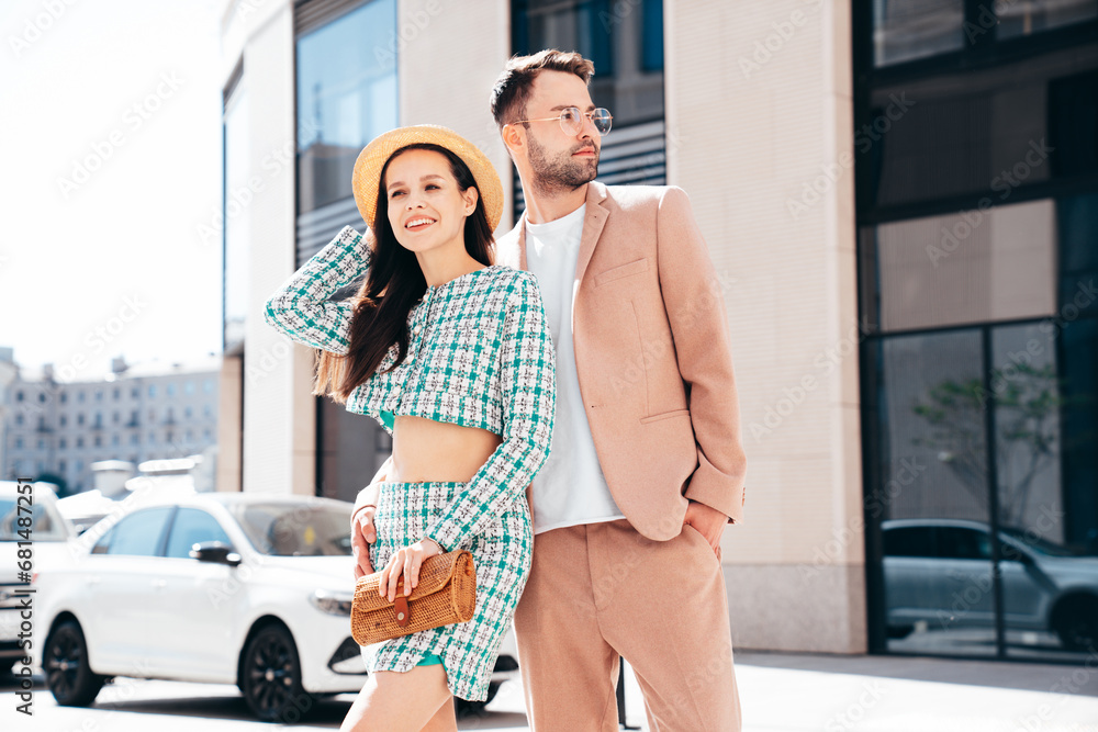 Beautiful fashion woman and her handsome elegant boyfriend in beige suit. Sexy brunette model in summer clothes. Fashionable smiling couple posing in street Europe. Brutal man and female outdoors