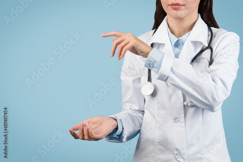 фотографія Female medic in white coat holds invisible object