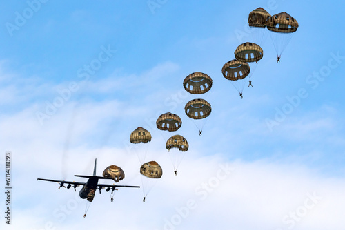 Military parachutist paratroopers parachute jumping out of an air force plane. photo
