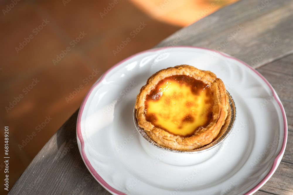 Portuguese egg tart on a white plate. Delicious pastry. Portuguese egg tart on a white plate. Delicious pastry.