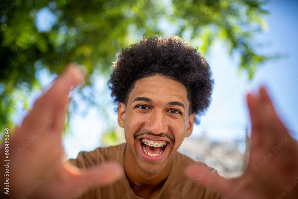 © mimagephotos - happy young african american man with hands forward