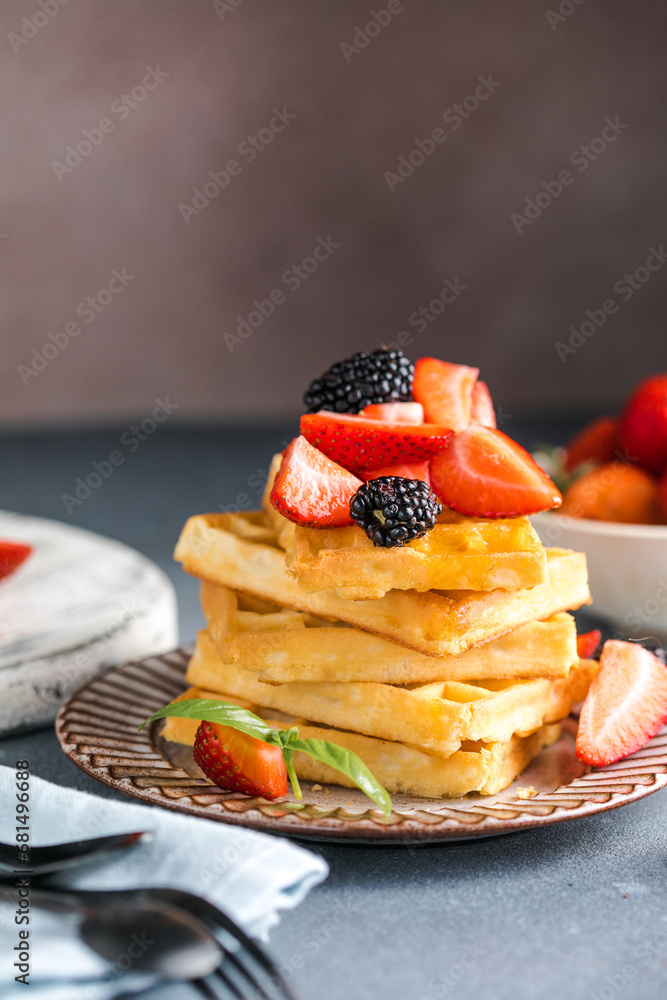 Waffles and Strawberries stacked on a plate. Belgian homemade waffles Waffles and Strawberries stacked on a plate. Belgian homemade waffles