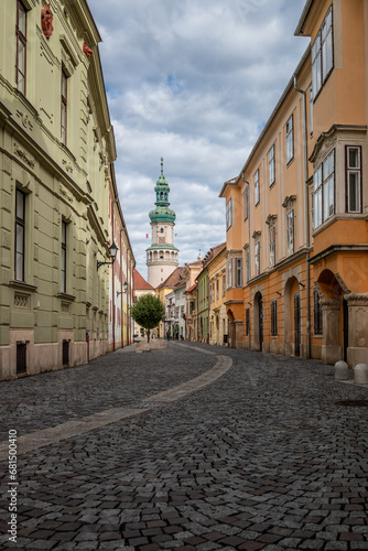 Narrow cobblestoned street in the downtown of Sopron  Hungary with the famour Fire Tower in the background 